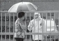  ?? AP/DANIEL CHAN ?? A Malaysian police officer talks to a woman Friday outside the forensic department at the Kuala Lumpur hospital.