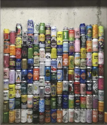  ?? MARY SCHWALM ?? A collection of empty beer cans consumed during the pandemic is seen at a home in North Andover, Mass.