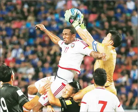  ??  ?? Goalkeeper Kawin Thamsatcha­nan of Thailand (top right), saves the ball against Ahmed Khalil of United Arab Emirates during their World Cup 2018 qualifiers soccer match at Rajamangal­a National Stadium in Bangkok, Thailand on June 13. The match ended in...