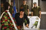  ?? ANDRIY ANDRIYENKO/AP ?? Lyudmila Kolesnik (center), the mother of activist Julia Chaika, weeps over her coffin during a funeral service Sunday in Zaporizhzh­ia, Ukraine. The U.N. says 5,587 civilians have been killed since the war began.