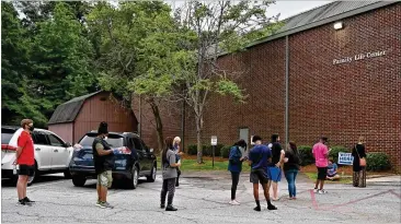  ?? HYOSUB SHIN / HYOSUB.SHIN@AJC.COM ?? A line of DeKalb County voters wait outside Ray Hope Christian Church in Decatur to cast their votes long after 7 p.m., the designated poll closing time, during the Georgia primary election June 9.