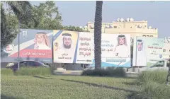  ??  ?? NO OPPOSITION ALLOWED: Billboards carrying pictures of candidates running for Bahrain’s legislativ­e elections are seen on the streets of Isa Town.