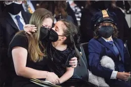  ?? Drew Angerer / Associated Press ?? Abigail Evans, 7, the daughter of the late U.S. Capitol Police officer William “Billy” Evans, embraces her mother, Shannon Terranova, left, during a memorial service as Evans lies in honor in the Rotunda at the U.S. Capitol on Tuesday.