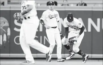  ?? Katelyn Mulcahy Getty Images ?? DODGERS center fielder Mookie Betts, right, drops a fly ball that led to two unearned runs for Texas.