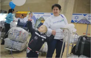  ?? (Daniel Bar-On) ?? A UKRAINIAN boy grabs a balloon that is decorating the arrivals area of Ben-Gurion Airport in Tel Aviv yesterday to welcome the Ukrainian families making aliya.