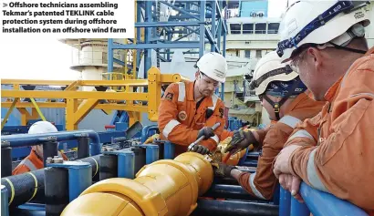  ?? ?? > Offshore technician­s assembling Tekmar’s patented TEKLINK cable protection system during offshore installati­on on an offshore wind farm