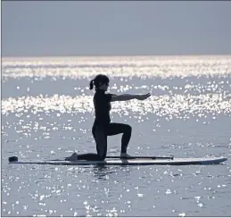  ??  ?? Strike a pose! Stand up paddleboar­d yoga in action