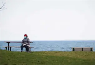 ?? NATHAN DENETTE THE CANADIAN PRESS ?? An elderly woman sits alone by Lake Ontario in Toronto on Monday. Ontario has given no dates or schedule for lifting COVID-19 restrictio­ns as the province approaches 1,000 deaths.
