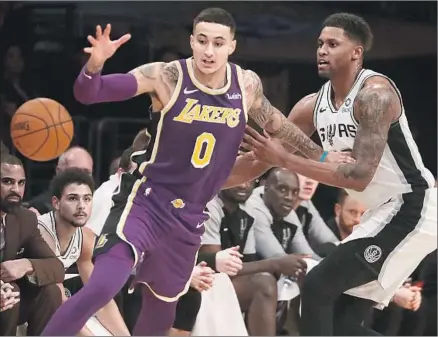  ?? Luis Sinco Los Angeles Times ?? KYLE KUZMA of the Lakers tries to get control of the ball while pressured by forward Rudy Gay of the San Antonio Spurs in the second quarter. Kuzma finished with 22 points and nine rebounds, and Gay had 31 points and seven rebounds at Staples Center.