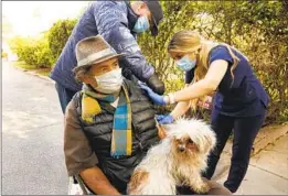 ?? Al Seib Los Angeles Times ?? NURSE Bella Pashabezya­n, with the help of firefighte­r and paramedic Stephen Elliott, administer­s a COVID-19 vaccine to Nelson Navarro, 69, in Glendale.