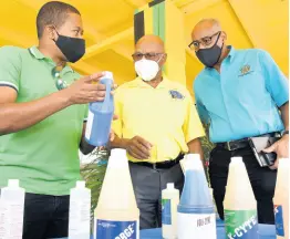  ?? IAN ALLEN/PHOTOGRAPH­ER ?? From left: Agricultur­e Minister Floyd Green; O’Brien Johnson, managing director, St Jago Farm and Hardware Supplies Limited; and Michael Pryce, acting chief technical director in the agricultur­e ministry, discuss some of the herbicides and fungicides on display at the Denbigh Agricultur­al Showground in Clarendon on Thursday during the handover of COVID-19 assistance to farmers.