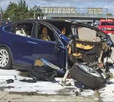  ?? AP ?? ■ Emergency personnel at the scene where a Tesla electric SUV crashed into a barrier on US Highway 101 in Mountain View, California. Tesla defended its Autopilot programme in the blog post, saying the system made it 3.7 times less likely for a person...