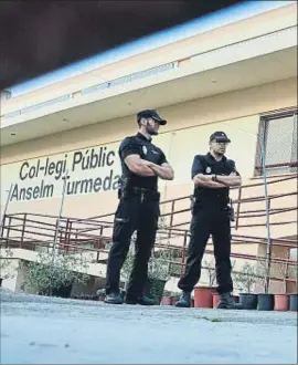  ?? ATIENZA / EFE ?? Dos policías locales a la entrada del colegio Anselm Turmeda