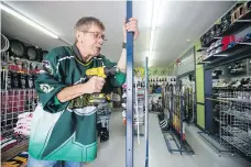  ??  ?? Mark Doepker, owner of Universal Sports, assembles a display stand at his store in Humboldt on Wednesday.