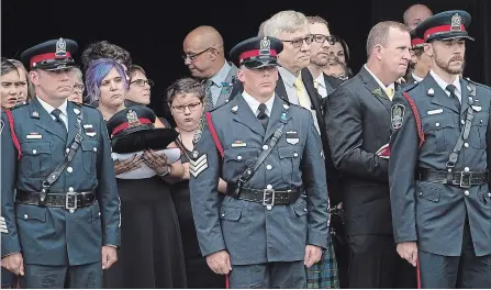  ?? ANDREW VAUGHAN THE CANADIAN PRESS ?? Jackie McLean, second from left, wife of Const. Robb Costello, and Steven Burns, second from right, husband of Const. Sara Burns, stand outside the Aitken University Centre after the regimental funeral in Fredericto­n on Saturday. The officers were among four people who died in a shooting.