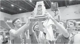  ?? PHOTOS BY MICHAEL LAUGHLIN/STAFF PHOTOGRAPH­ER ?? Westminste­r Academy players display their 4A state finals trophy. They celebrated an 89-64 win over Oviedo Master’s Academy on Thursday afternoon at RP Funding Center.