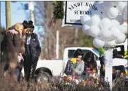  ?? Marcus Yam/The New York Times ?? People visit a makeshift memorial for the victims of the Sandy Hook Elementary School shooting in 2012.