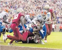  ??  ?? Florida quarterbac­k Feleipe Franks (13) is brought down short of the goal line by FSU’s Jaiden Woodbey (20) during the Gators’ win Saturday in Tallahasse­e.