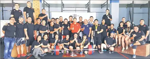  ??  ?? Ong (centre) with the organising committee and participan­ts at CrossFit Kuching yesterday.