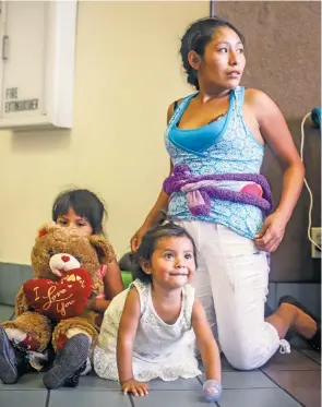  ?? GABRIELA CAMPOS/THE NEW MEXICAN ?? Andrea and her two young daughters, who arrived from Guatemala earlier in the month, wait at the Greyhound bus station in downtown El Paso. They will travel to Florida to meet with family and await their court hearing. In recent years there has been an influx of immigrants from Central America, especially Guatemala and Honduras.