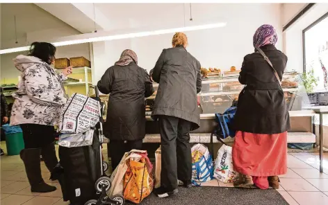  ?? FOTO: ANDREAS ARNOLD/DPA ?? Vier Frauen stehen an der Brottheke einer Tafel (Symbolbild). Während der Corona-Krise hatten viele Tafeln zunächst geschlosse­n. Für bedürftige Familien war dies eine besonders schwere Zeit.