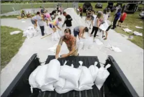  ?? DAVID GOLDMAN — THE ASSOCIATED PRESS ?? Ryan Kaye loads sandbags into his truck at a makeshift filling station provided by the county as protection ahead of Hurricane Irma, Friday in Palm Coast, Fla.