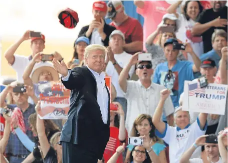  ?? Picture: AP. ?? President Trump throws a cap into the crowd at a rally in Melbourne, Florida, at the weekend.