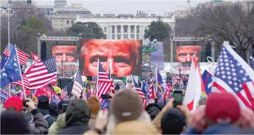  ?? JOHN MINCHILLO/AP FILES ?? The face of then-President Donald Trump appears on large screens at a rally on Jan. 6, 2021, prior to the insurrecti­on at the U.S. Capitol.