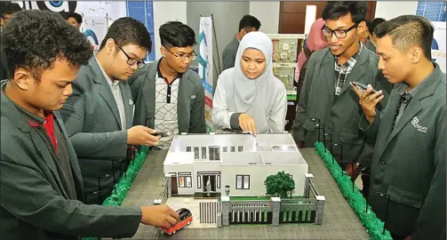  ?? AHMAD KHUSAINI/JAWA POS ?? KOLABORASI: Dosen S-1 Sistem Komputer Stikom Surabaya Musayyanah (empat dari kiri) membimbing mahasiswa baru menerapkan teknologi ke dalam smart house.