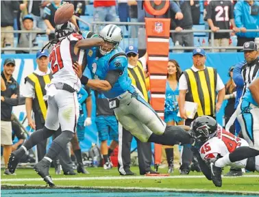  ?? THE ASSOCIATED PRESS ?? Atlanta Falcons cornerback Desmond Trufant (21) and teammate Deion Jones, right, are unable to keep Carolina Panthers quarterbac­k Cam Newton out of the end zone for a touchdown during the first half of Sunday’s game in Charlotte, N.C.