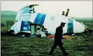  ?? MARTIN CLEAVER — THE ASSOCIATED PRESS FILE ?? A police officer walks by the nose of Pan Am flight 103 in a field near the town of Lockerbie, Scotland where it lay after a bomb aboard exploded, killing a total of 270 people, Wednesday, Dec. 21, 1988.