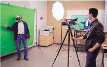  ?? ANTONIO SANCHEZ/RIO RANCHO OBSERVER ?? CNM board member Tom Swisstack wears a virtual reality headset and stands in front of a green screen at an open house event at the college, while CNM student Michael Durden mans the camera.