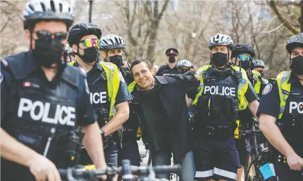  ?? — REUTERS ?? Toronto police detain a man who was part of a group protesting against the COVID-19 lockdown restrictio­ns in Toronto last week.