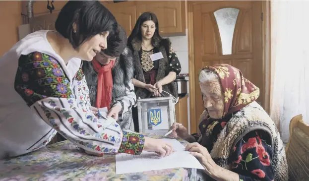  ?? PICTURE: GETTY IMAGES ?? 0 A villager fills in a ballot paper in her house near the western city of Lviv during the second round of Ukraine’s presidenti­al election