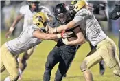  ?? JIM RASSOL/STAFF PHOTOGRAPH­ER ?? Palm Beach Central quarterbac­k Nick Atkins tries to run in a two-point conversion past two Western defenders during Friday night’s Class 8A regional semifinal.