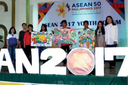  ?? Photo by Lito Dar ?? ASEAN POSTER MAKING. PIA Regional Director Helen Tibaldo (left) with guest speaker NCRPO Spokespers­on Kimberly Molitas (right) joins winners of the ASEAN Visual Arts Poster making contest at the Benguet State University.
