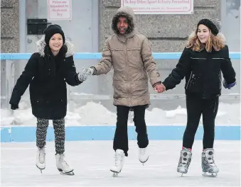  ??  ?? Ray Wah Say, 11, left, Mawaheb Hassan, 11, centre, and Isabella Kemeny, 10, spent hours at the rink on Saturday, despite a light rain.