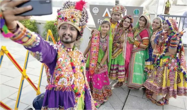  ?? Associated Press ?? ±
People in traditiona­l attire pose for a selfie after practicing Garba, a traditiona­l dance of Gujarat state, ahead of Navratri in Ahmedabad, on Monday.