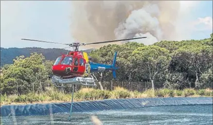  ?? LLIBERT TEIXIDÓ ?? Una treintena de vehículos de los bomberos y cuatro medios aéreos remojaron ayer el perímetro