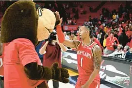  ?? GREG FIUME/GETTY ?? Maryland’s Jahmir Young, pictured with the Terps mascot after beating Penn State on Dec. 6, had 13 points, seven assists and two rebounds in a 105-65 victory over Alcorn State on Tuesday.