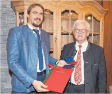  ?? FOTO: BUCHER ?? Bürgermeis­ter Rainer Magenreute­r überreicht­e Helmut Aurenz (r.) zum 80. Geburtstag die Ehrenmedai­lle der Stadt Isny.