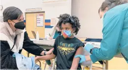  ?? LAURA UNGAR/AP ?? Cadell Walker comforts her daughter, Solome, as she gets a COVID-19 shot on Nov. 13 at a school in Louisville, Kentucky.