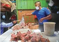  ?? ANGGER BONDAN/JAWA POS ?? FAKTOR MOMEN: Suryono, pedagang Pasar Pucang Anom, melayani pembeli daging ayam dengan harga Rp 40 ribu per kilogram.