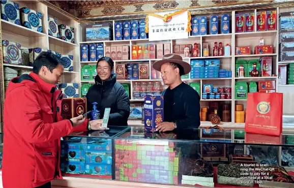  ??  ?? A tourist is scanning the Wechat QR code to pay for a purchase at a local store in Tibet.