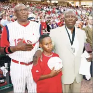  ?? David Kohl / Associated Press ?? Then-Cincinnati Reds manager Dusty Baker, left, stands with his son Darren Baker, center, and baseball great Hank Aaron as the national anthem is played at the Civil Rights Game ceremony before a game between the Chicago White Sox and the Cincinnati Reds in Cincinnati in 2009. Baker, now the manager of the Houston Astros, and Brian Snitker, manager of the Atlanta Braves, say Aaron would have loved being able to watch this World Series.