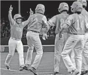  ?? [AP PHOTO] ?? Honolulu’s Sean Yamaguchi (left) is greeted by teammates after hitting a grand slam off Staten Island’s Chris Bedford during the second inning of Wednesday’s game at the Little League World Series in South Williamspo­rt, Pa.