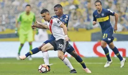  ?? FOTO AFP ?? Imagen del duelo de ida en La Bombonera, que finalizó 2-2. En la acción, los colombiano­s Rafael Santos y Wílmar Barrios. El jugador de River no podrá actuar en el Bernabéu, por sanción.