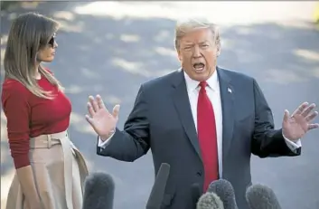  ?? Saul Loeb/AFP/Getty Images ?? President Donald Trump speaks to the media alongside first lady Melania Trump on the South Lawn of the White House Tuesday before departing on a weeklong trip to Europe, with stops in Brussels, London, Scotland and Helsinki.