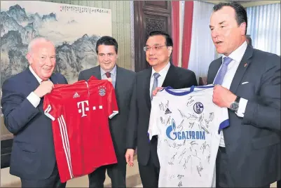  ?? PANG XINGLEI / XINHUA ?? Premier Li Keqiang meets German Vice-Chancellor and Foreign Minister Sigmar Gabriel (second from left) and receives soccer club jerseys from the visiting German delegation in Beijing on Wednesday.