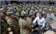  ?? AP PHOTO BY ROSS D. FRANKLIN ?? Arizona's Republican Gov. Doug Ducey, front right, meets with Arizona National Guard soldiers prior to their deployment to the Mexico border at the Papago Park Military Reservatio­n on Monday in Phoenix.